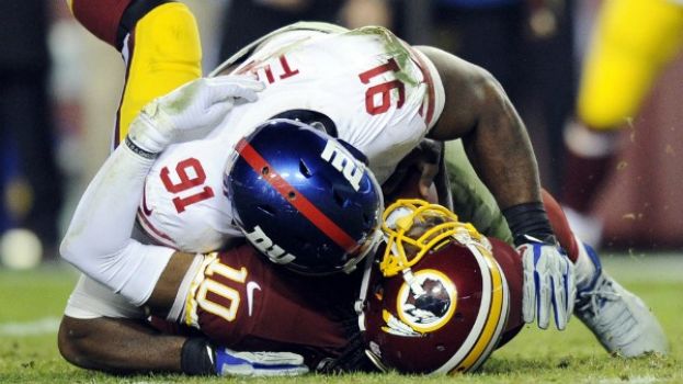 New York Giants defensive end Justin Tuck (91) sacks Washington Redskins quarterback Robert Griffin III (10) during the second half of an NFL football game Sunday, Dec. 1, 2013, in Landover, Md.